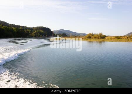 Wasserweg von Erholungsboot im Urdaibai Biosphärenreservat an sonnigen Tag verlassen. Motorbootfahrt mit dem Fluss auf Naturlandschaft Stockfoto