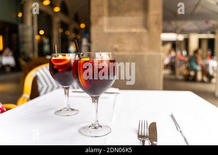 Zwei rote Sangria-Gläser auf weißer Tischdecke im Restaurant Stockfoto