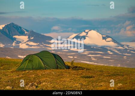 Zelt mit Sarek Nationalpark hohe Berge im Hintergrund, Wandern entlang der Kingstrail im Stora sjöfallet Nationalpark im Sommer, Schwedisch La Stockfoto