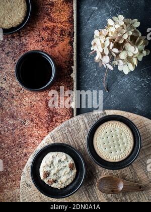 Verschiedene Arten von Cookies und Tasse Kaffee auf grau und Teracota Hintergrund. Overhead-Aufnahme. Stockfoto