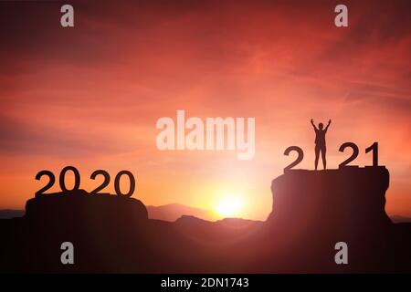 2021 Konzept, Wandern von 2020 bis 2021 Neujahr Silhouette junge Frau stehend und heben die Hand bis zum glücklichen neuen Jahr mit Sonnenaufgang, Sonnenuntergang Hintergrund Stockfoto