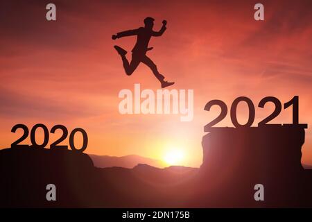 2021 Konzept, Geschäftsmann jumpng up von 2020 bis 2021 Newyear Silhouette junge Frau stehen und heben Hand bis zum glücklichen neuen Jahr mit Sonnenaufgang, so Stockfoto