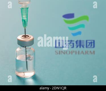 Athen, Griechenland. Dezember 17, 2020. Sinopharm China-Impfstoff-Logo auf blauem Hintergrund. Covid19 Impfstofffläschchen und Spritze, Coronavirus-Immunisierungskonzept Stockfoto