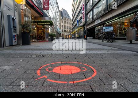 Erster Tag der weihnachtlichen Sperre in der Corona-Krise, leere Einkaufsstraße, geschlossene Geschäfte, kaum Passanten, Logo auf dem Boden, Hinweis auf com Stockfoto