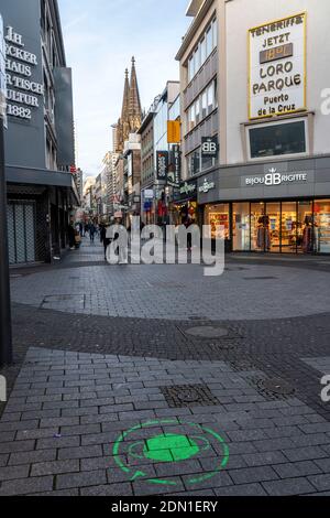 Erster Tag der weihnachtlichen Sperre in der Corona-Krise, leere Einkaufsstraße, geschlossene Geschäfte, kaum Passanten, Logo auf dem Boden, Hinweis Stockfoto