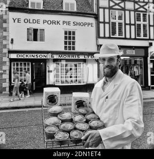 Ein Bäcker hält ein Tablett mit Melton Mowbray Schweinebraten & Melton Hunt Kuchen außerhalb Ye Olde Pork Pie Shoppe. Melton Mowbray. Leicestershire. England, Großbritannien Stockfoto