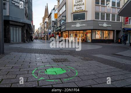 Erster Tag der weihnachtlichen Sperre in der Corona-Krise, leere Einkaufsstraße, geschlossene Geschäfte, kaum Passanten, Logo auf dem Boden, Hinweis Stockfoto