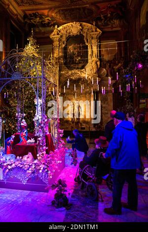 Großbritannien, England, Derbyshire, Edensor, Chatsworth House Chapel zu Weihnachten, landet weit weg, Spanien, Besucher in Sheelchair bei der Krippe Stockfoto