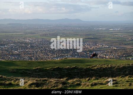 Am 22. November 2020 in Cheltenham, Großbritannien, genießen die Menschen den Blick über Gloucestershire auf Bishops Cleve von Cleve Hill aus. Cleeve Hill ist der höchste Punkt sowohl der Cotswolds Hill Range und der Grafschaft Gloucestershire, mit 1,083 Fuß. Es befindet sich auf Cleeve Common, die eine Website von besonderem wissenschaftlichem Interesse ist, die von einer kleinen Wohltätigkeitsorganisation namens Cleeve Common Trust betreut wird. Stockfoto