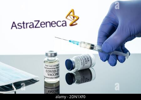 Morgantown, WV - 16. Dezember 2020: Kleine Flasche Coronavirus-Impfstoff mit Spritze mit Hintergrund des AstraZeneca-Logos Stockfoto