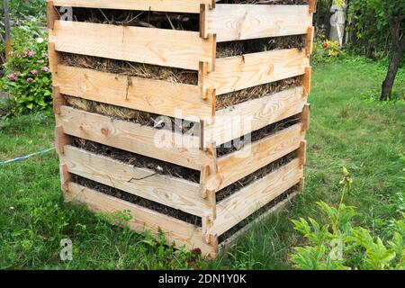 Einfacher Holzkomposter aus Planken mit Lücken für einfache Zugang der Luft zur Kompost-Garteneimer Stockfoto