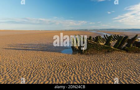 Die Holzreste des Wracks der norwegischen Barke SS Nornen (1897) am Strand von Berrow Flats in Somerset, England, bei Ebbe. Stockfoto