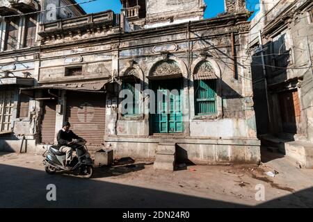 Jamnagar, Gujarat, Indien - Dezember 2018: Alte, verfallende, alte Häuser mit bunten Holztüren auf den Straßen der Altstadt von Jamnagar. Stockfoto