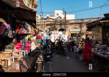 Jamnagar, Gujarat, Indien - Dezember 2018: Ein Mann, der in einem LKW Waren in den chaotischen Straßen eines Marktes in der Altstadt transportiert. Stockfoto