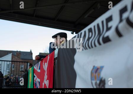 Ein Zuschauer in der Haupttribüne, der die erste Halbzeit beobachtet, als Marine Hyde United in einer FA Trophy erste Runde in der Marine Travel Arena, früher bekannt als Rossett Park, in Crosby spielt. Aufgrund der Coronavirus-Vorschriften, die Ligaspiele ausgesetzt hatten, waren die einzigen Spiele der Merseysider in Pokalwettbewerben, einschließlich ihres bevorstehenden Gleichspiels gegen Tottenham Hotspur in der dritten Runde des FA Cup. Marine gewann das Spiel mit 1:0, beobachtet mit einer zulässigen Kapazität von 400, mit den Besuchern, die zwei Männer in der zweiten Hälfte geschickt. Stockfoto