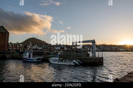 North Berwick, East Lothian, Schottland, Vereinigtes Königreich, 17. Dezember 2020. UK Wetter: Sonnenuntergang über West Bay und North Berwick Hafen mit festverankerten Fischerbooten Stockfoto