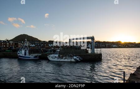 North Berwick, East Lothian, Schottland, Vereinigtes Königreich, 17. Dezember 2020. UK Wetter: Sonnenuntergang über West Bay und North Berwick Hafen mit festverankerten Fischerbooten Stockfoto