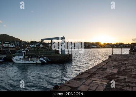 North Berwick, East Lothian, Schottland, Vereinigtes Königreich, 17. Dezember 2020. UK Wetter: Sonnenuntergang über West Bay und North Berwick Hafen mit einem festmachen Fischerboot Stockfoto