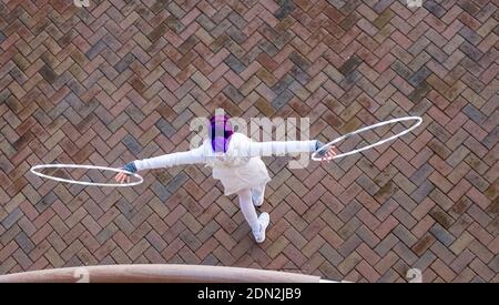 Brighton UK 17. Dezember 2020 - AA Hula Hooping Busker unterhält Besucher an der Küste von Brighton am Ende eines hellen Tages an der Südküste . Die Stadt Brighton und Hove wurde in Coronavirus Tier zwei Beschränkungen in England nach einer Ankündigung heute von der Gesundheitsminister Matt Hancock gehalten : Credit Simon Dack / Alamy Live News Stockfoto