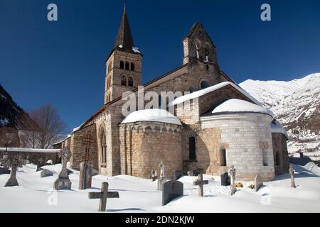 Horizontale Außenansicht der romanischen Kirche Santa María mit Apsis und schneebedecktem Friedhof, Artíes, Vall d’Aran, Lleida, Katalonien Stockfoto