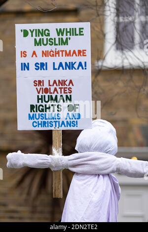 Plakat und in Leinen gehüllte Figur bei Protest gegen die erzwungene Einäscherung von COVID-19 Opfern in Sri Lanka, Botschaft von Sri Lanka, London, 12. Dezember 2020 Stockfoto