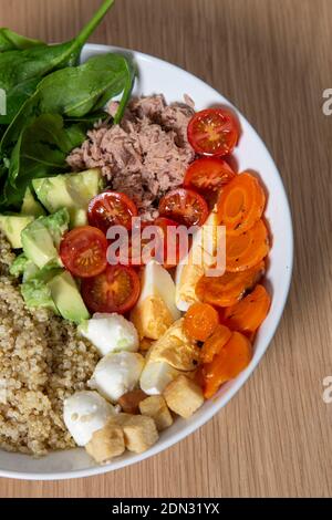 Gesunde Salatschüssel mit Avocado, Tomaten, Karotten, Thunfisch und Quinoa. Vertikales isoliertes Bild Stockfoto