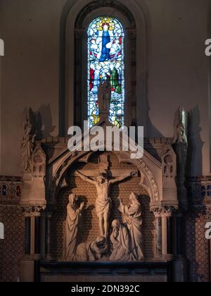 Steinreredos mit Kreuzigung Szene unterhalb der Edikula im östlichen Ende Apsidal der Holy Trinity Church, Dilton Marsh, Wiltshire, England, UK. Stockfoto