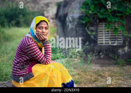 Young beatutiful gypsy woman in traditional clothes and deep in thought in the Thar desert at dawn near Pushkar, Rajasthan, India. Stockfoto