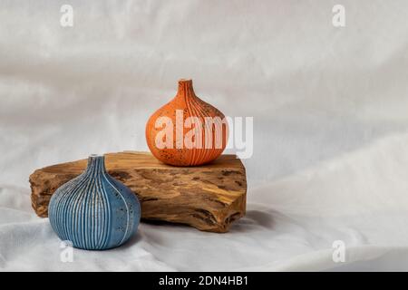 Zwei schöne kleine Keramikvasen mit Holzstämmen auf weißem Hintergrund. Keramik Geschirr, Wohnkultur. Stockfoto