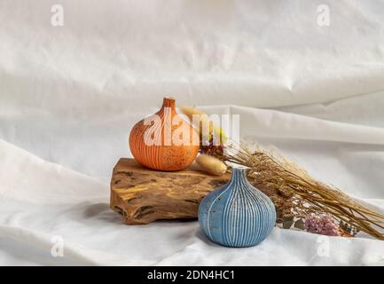 Zwei schöne kleine Keramikvasen mit Holzstämmen und getrockneten Blumen auf weißem Hintergrund. Keramik Geschirr, Wohnkultur. Stockfoto