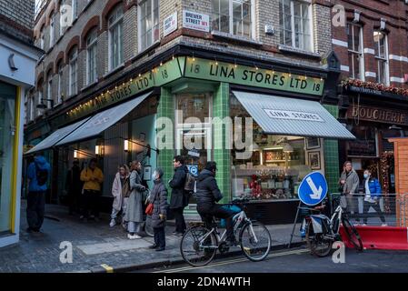 London, Großbritannien. 17 Dezember 2020. Vor einem Lebensmittelgeschäft in Soho stehen die Menschen Schlange, da die Hauptstadt mit Tier 3, sehr hoher Alarmstufe, Einschränkungen unterliegt, während die Coronavirus-Pandemie andauert. Kredit: Stephen Chung / Alamy Live Nachrichten Stockfoto