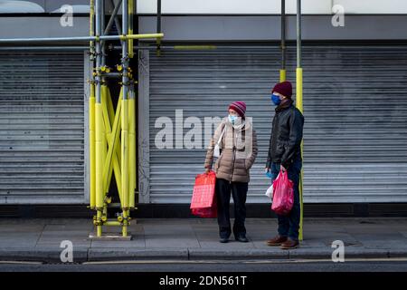 London, Großbritannien. 17 Dezember 2020. Ein Paar trägt Gesichtsmasken in Chinatown. Shaftesbury Plc, Eigentümer von Immobilien in Soho, Covent Garden, Carnaby Street und Chinatown, hat angekündigt, dass es den Wert seiner Londoner Restaurants, Bars und Geschäfte um fast 700 Millionen GBP (932 Millionen USD) aufschreibt. Da die Mieteinnahmen um 24 % gesunken sind und die Geschäfte während der laufenden Coronavirus-Pandemie Schwierigkeiten haben, den Handel zu halten. Der Kapitalzustieg auf Stufe 3 sehr hohe Alarmstufe wird nur dazu dienen, die Situation zu verschärfen. Kredit: Stephen Chung / Alamy Live Nachrichten Stockfoto