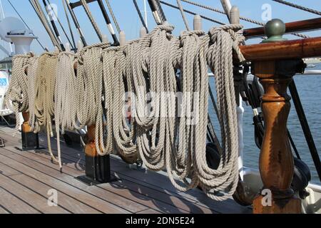 Eine Nahaufnahme von coled Seilen hängen von hölzernen Geländern Ein Schiff Stockfoto