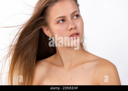 Porträt eines blonden, ehrfürchtigen Mädchen, Blick auf die Seite. Weißer Hintergrund. Beauty, Spa, Haarpflege und Wellness-Konzept. Stockfoto