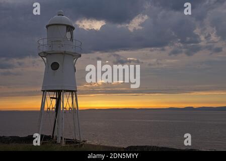 Ein Sonnenuntergangsbild mit dem Black Nore Lighthouse mit Blick auf den Bristol Channel an der Küste in der Nähe von Portishead, Somerset, England, Großbritannien. Stockfoto