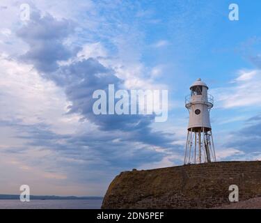 Ein Sonnenuntergangsbild mit dem Black Nore Lighthouse mit Blick auf den Bristol Channel an der Küste in der Nähe von Portishead, Somerset, England, Großbritannien. Stockfoto