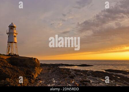 Ein Sonnenuntergangsbild mit dem Black Nore Lighthouse mit Blick auf den Bristol Channel an der Küste in der Nähe von Portishead, Somerset, England, Großbritannien. Stockfoto