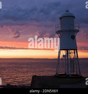 Ein Sonnenuntergangsbild mit dem Black Nore Lighthouse mit Blick auf den Bristol Channel an der Küste in der Nähe von Portishead, Somerset, England, Großbritannien. Stockfoto