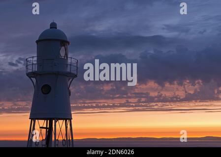 Ein Sonnenuntergangsbild mit dem Black Nore Lighthouse mit Blick auf den Bristol Channel an der Küste in der Nähe von Portishead, Somerset, England, Großbritannien. Stockfoto