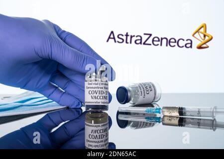 Morgantown, WV - 16. Dezember 2020: Kleine Flasche Coronavirus-Impfstoff mit Spritze mit Hintergrund des AstraZeneca-Logos Stockfoto