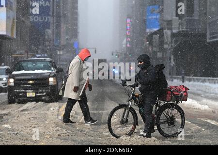 New York, USA. 17th Dec, 2020. A food delivery person on a bicycle waits to cross 42nd Street at the tail end of a nor'easter that brought more than a foot of snow to some parts of the city, New York, NY, December 17, 2020. As a COVID-19 pandemic second wave grips the United States, restaurants continue to struggle as cities like New York have one again banned indoor dining, as well as outdoor dining during the snowstorm. (Photo by Anthony Behar/Sipa USA) Credit: Sipa USA/Alamy Live News Stock Photo