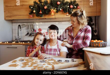 Eine freundliche Familie bereitet Ingwerkekse in der Küche zu. Stockfoto