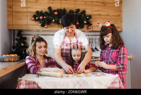 Eine freundliche Familie bereitet Ingwerkekse in der Küche zu. Stockfoto