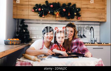 Die Familie in der Küche bereitet sich auf Weihnachten vor und hat Spaß daran, Kekse zu machen. Familientraditionen. Stockfoto