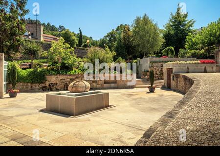 Thermalquelle der Termas de São Pedro do Sul in Portugal, mit dem Jardim das Termas im Hintergrund, an einem Sommernachmittag. Stockfoto