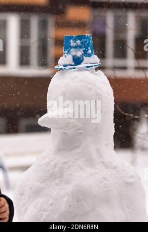 Schneemann im Hof mit einem Eimer auf dem Kopf. Stockfoto