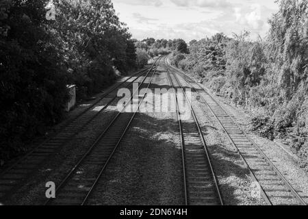 Schwarz-Weiß-Foto von verlassenen Eisenbahnlinien oder Bahngleisen, die in die Ferne führen, wer weiß, wohin sie reisen? Stockfoto