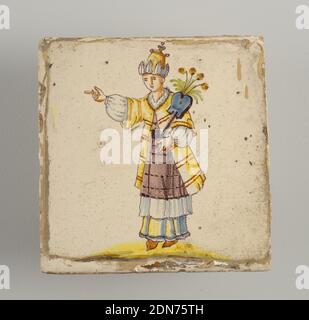 Tile, Earthenware, glazed and high fire decorated, Standing man, pointing to the left and carrying winged and flowered blue staff in his left hand; dress of layers of bluish-white and manganese skirts, with yellow coat; high head dress. Chinoiserie type of decoration., Alcora, Spain, late 18th–early 19th century, tiles, Decorative Arts, Tile Stock Photo