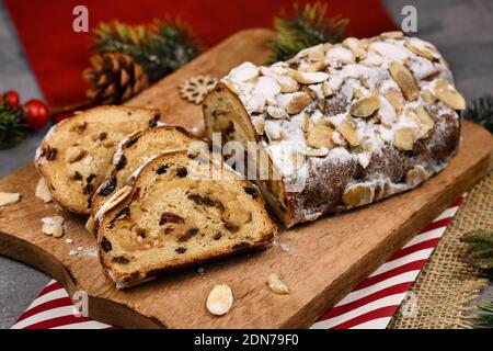 Deutscher Stollenkuchen mit Scheiben, ein Obstbrot mit Nüssen, Gewürzen und Trockenfrüchten mit Puderzucker traditionell während der Weihnachtszeit serviert Stockfoto