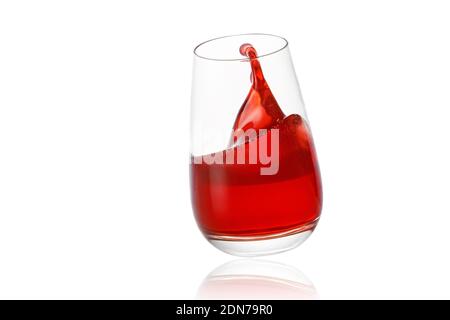 Rote Limonade spritzt ins Glas auf weißem Hintergrund Stockfoto